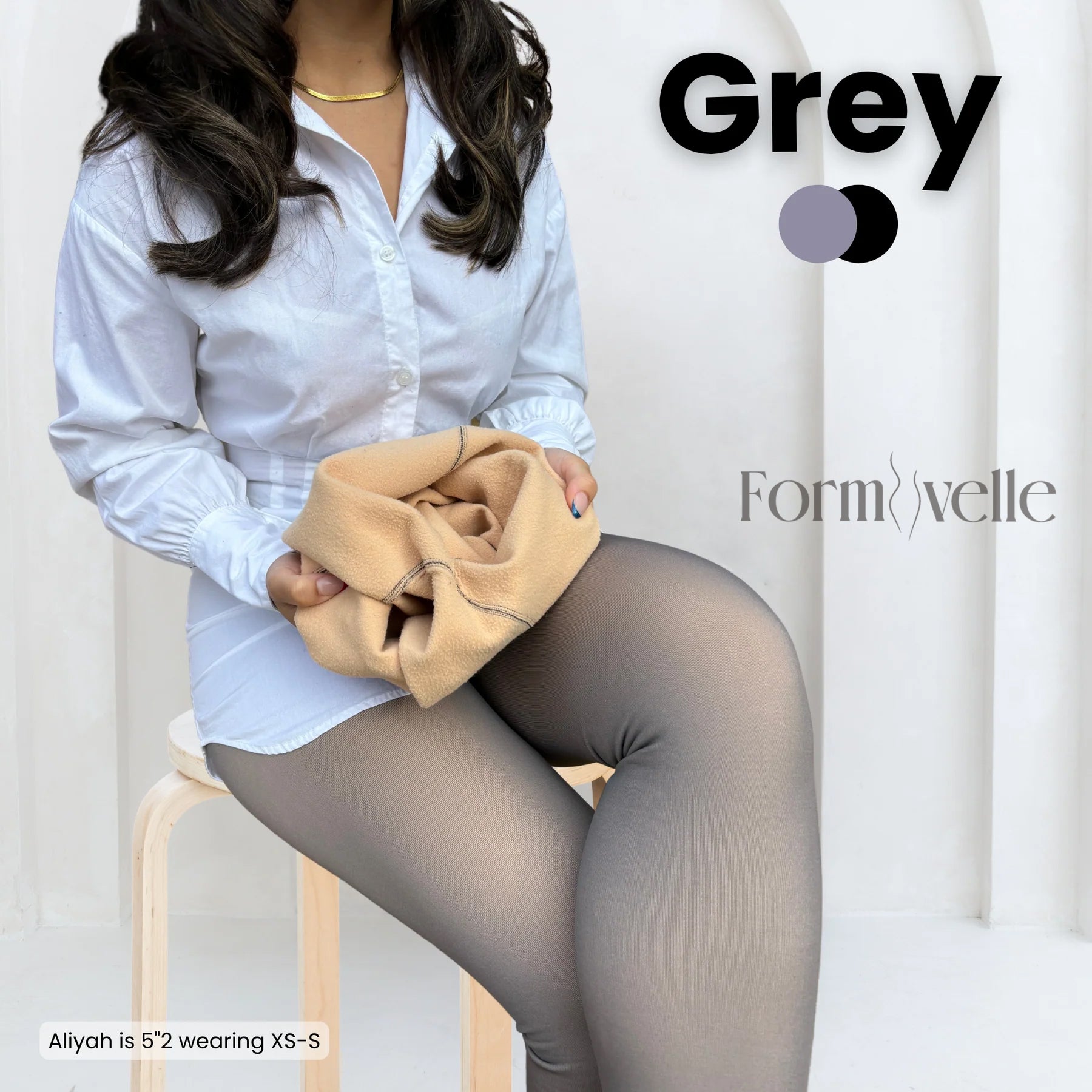 Woman wearing Formivelle grey fleece-lined tights and white shirt, holding tan lining fabric.