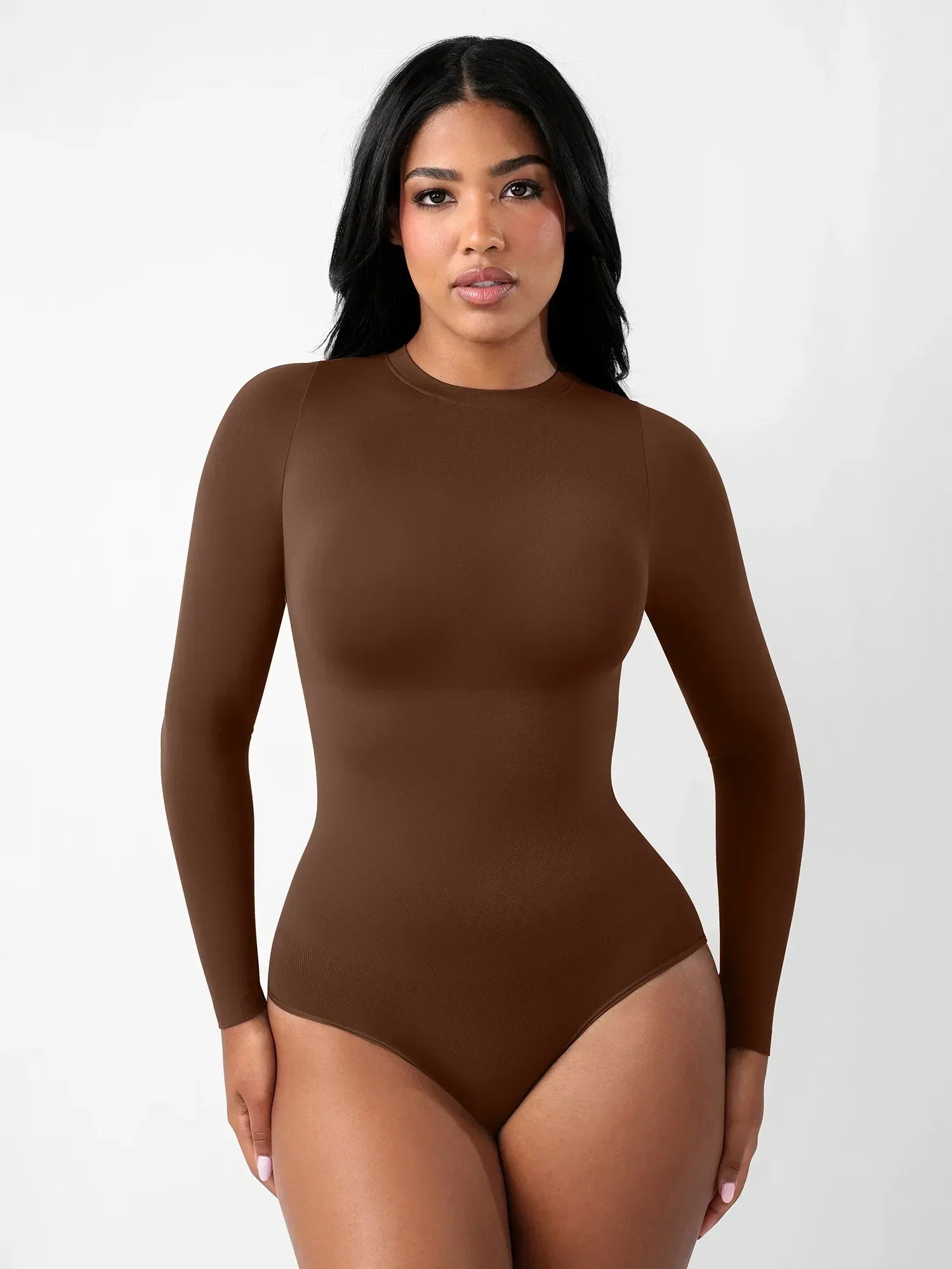 Woman wearing a seamless brown long sleeve crew neck bodysuit by Formivelle against a white background.