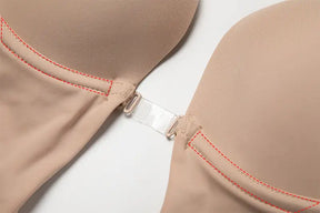 Close-up of beige Formivelle backless body shaper bra with front clasp and red stitching