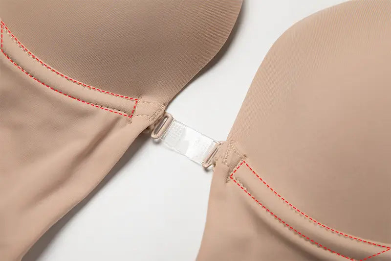 Close-up of beige Formivelle backless body shaper bra with front clasp and red stitching