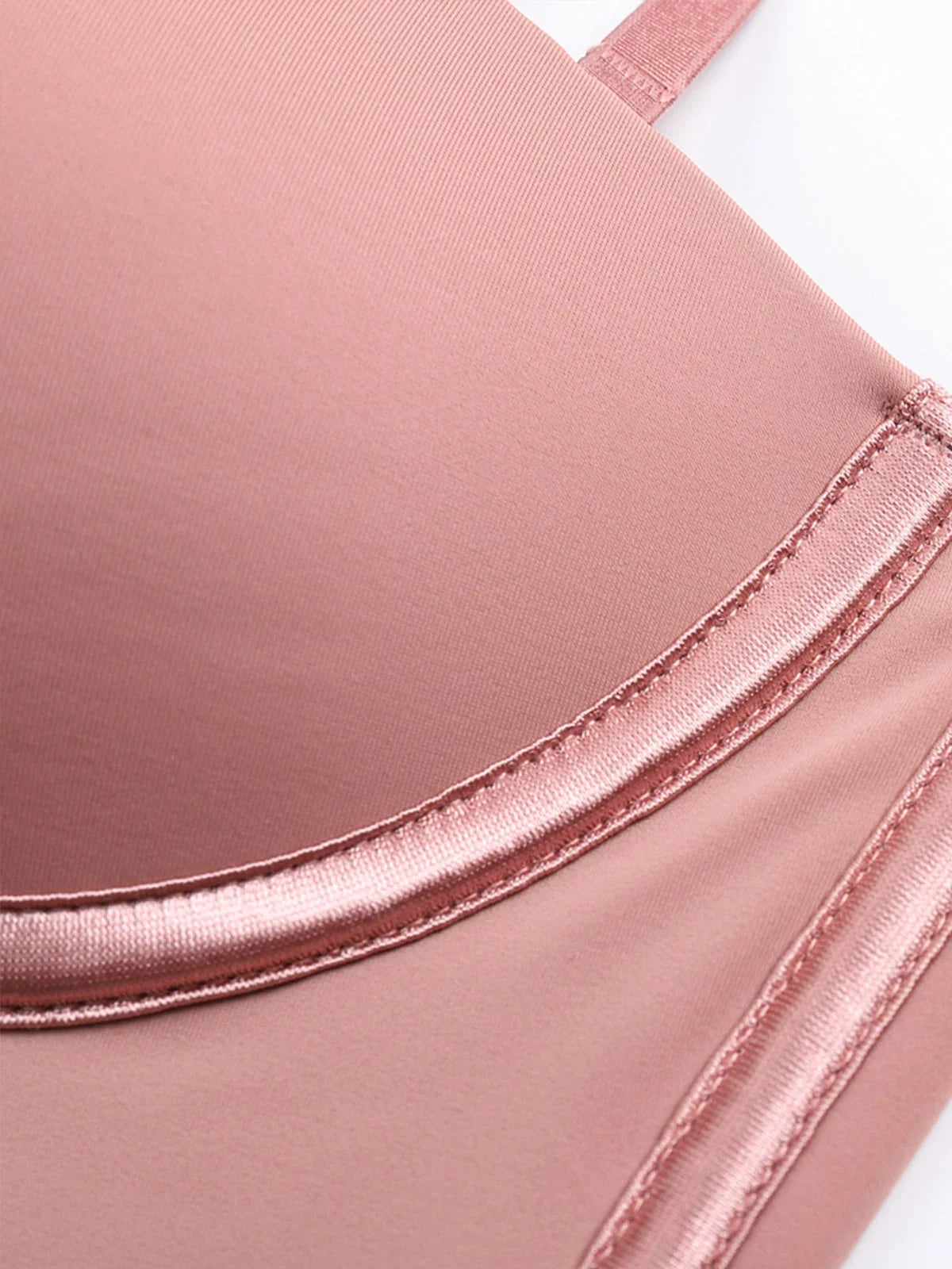 Close-up of Formivelle blush pink push-up corset bodysuit with satin trim detail
